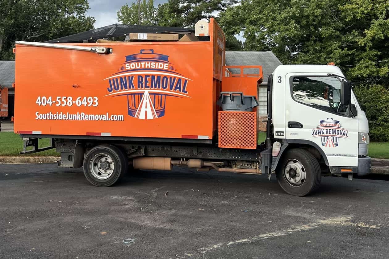 Southside junk removal truck parked on a street, its orange box showing the logo, phone number and website