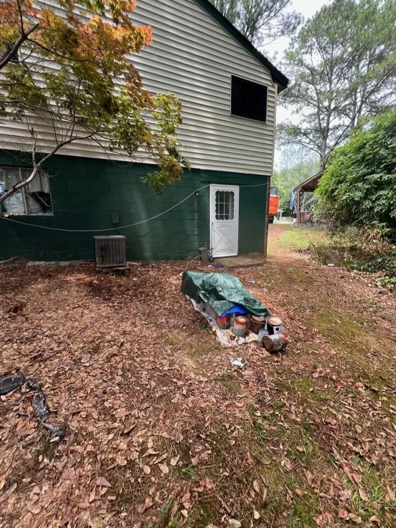 The same side yard cleared down to bare mulch after the crew hauled everything