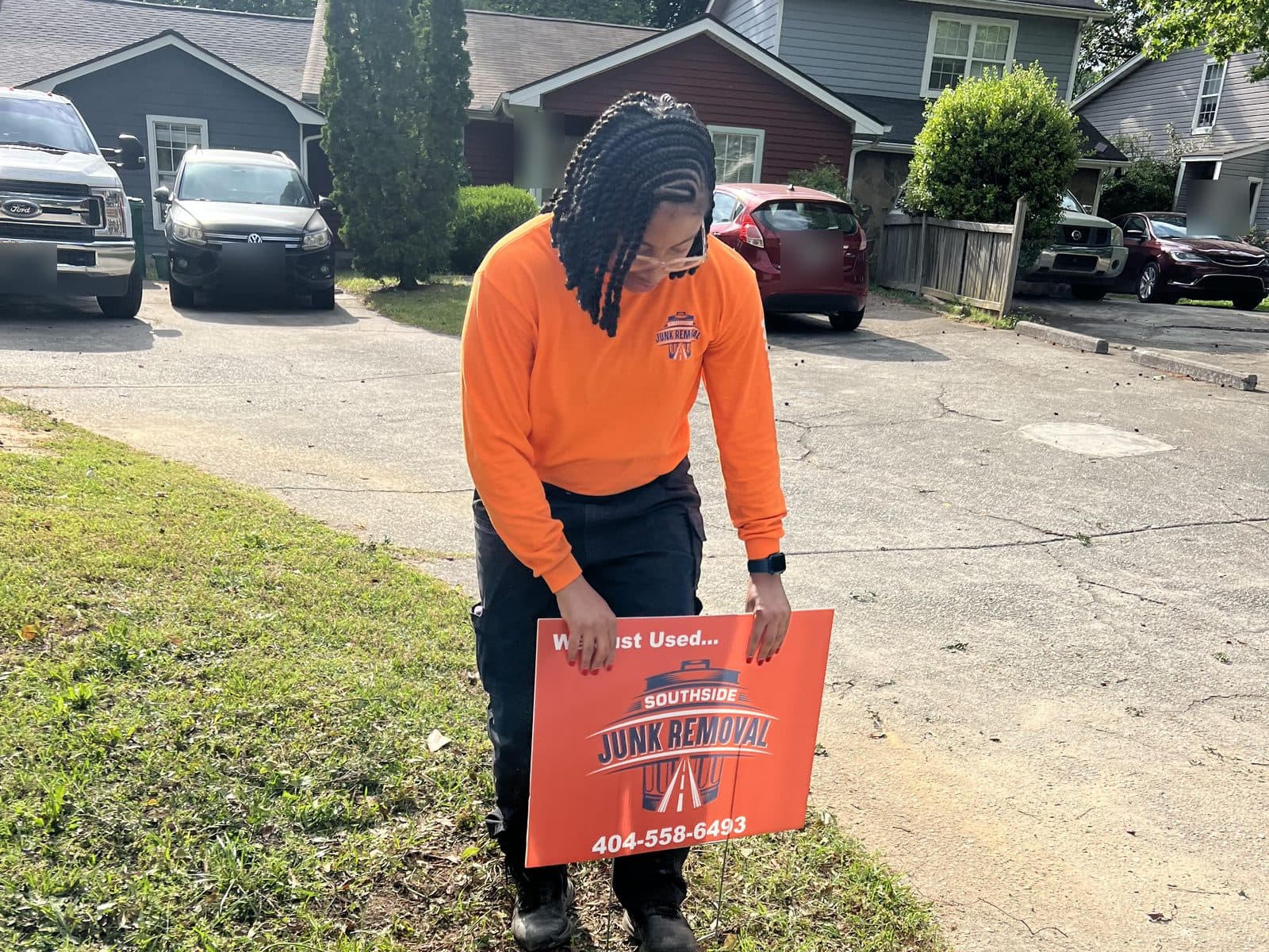 Southside crew member placing a "We just used Southside" yard sign at the curb after a job