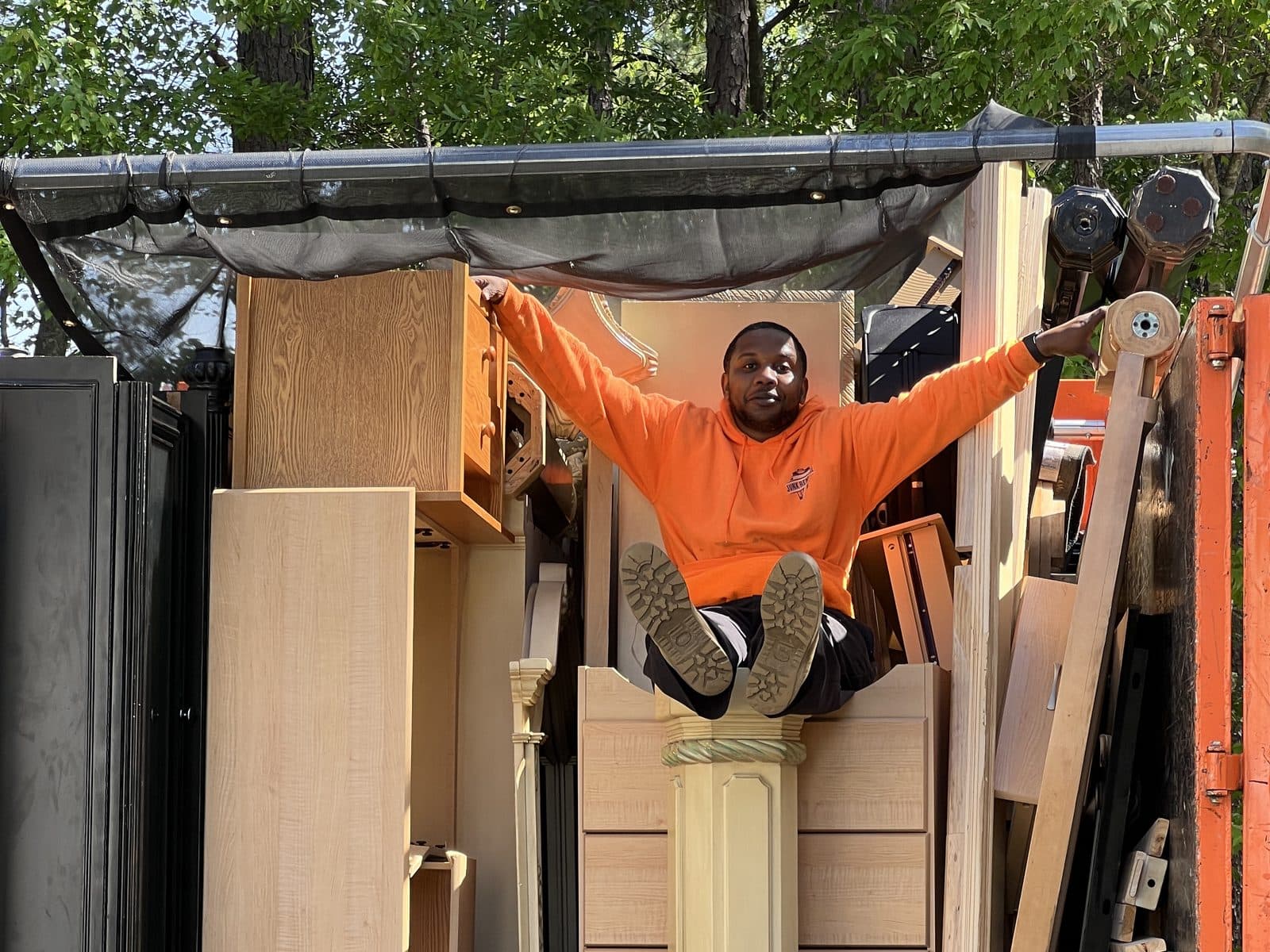 Southside crew member sitting on top of a truck packed full of cabinets, dressers and other furniture