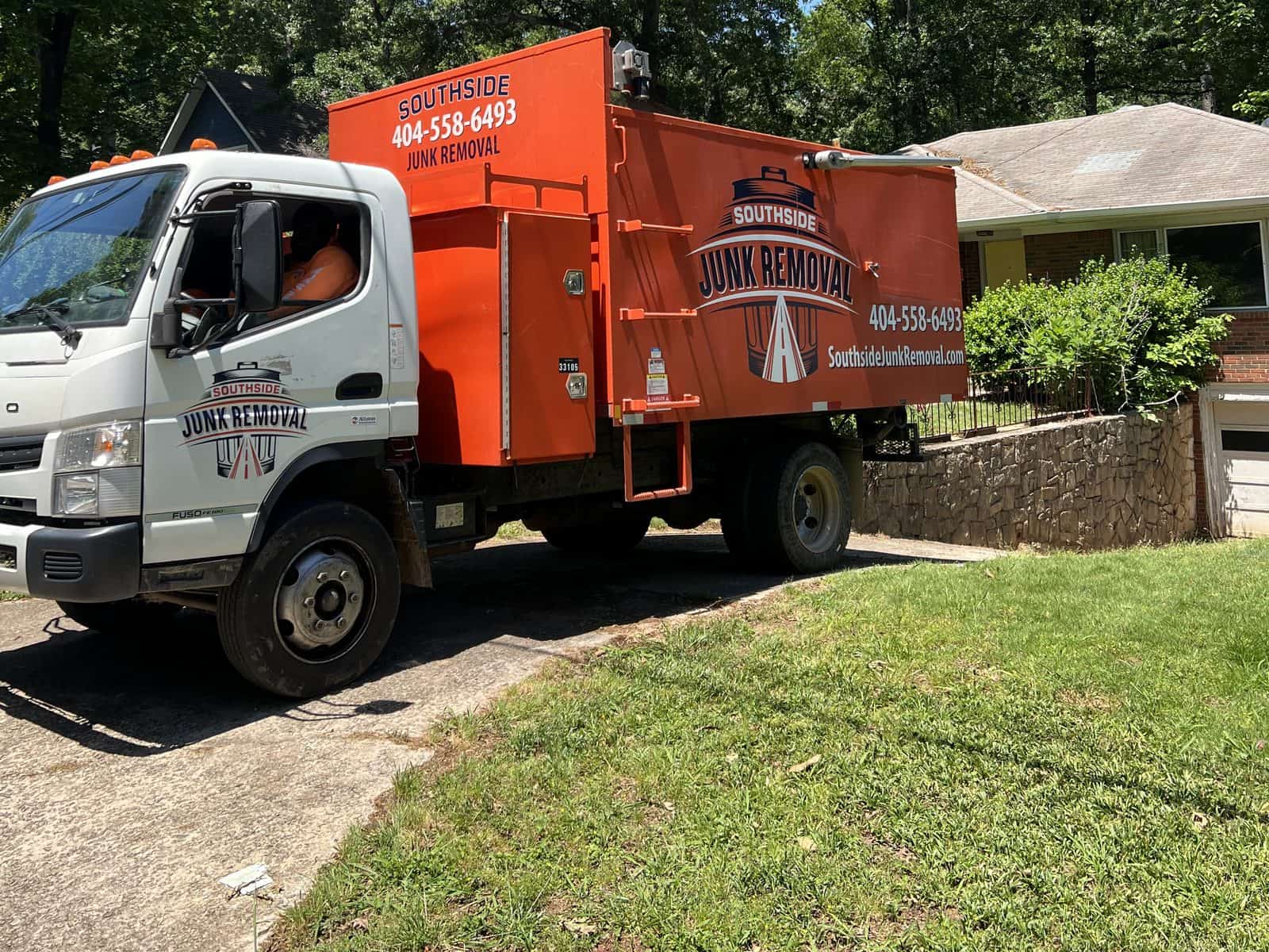 Southside junk truck in the driveway of a brick ranch home on a sunny day
