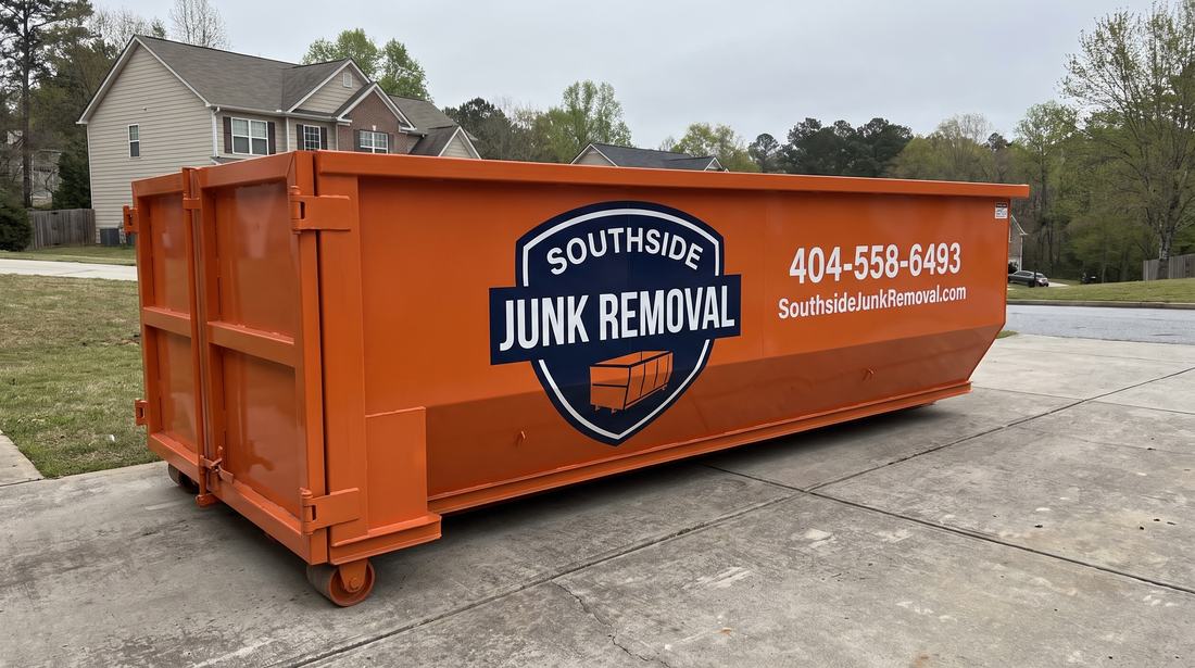Empty orange Southside Junk Removal roll-off dumpster delivered on a driveway in Conyers, Georgia