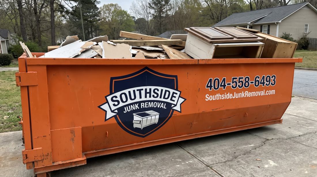 Orange Southside Junk Removal roll-off dumpster half filled with construction debris on a driveway in East Point, Georgia