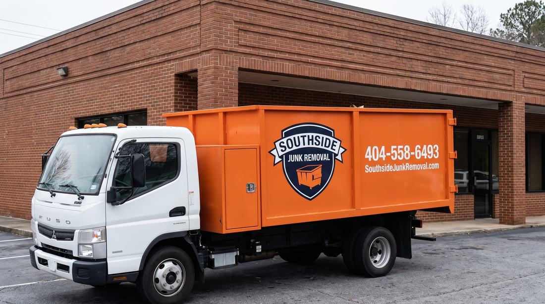 Orange Southside Junk Removal dump truck parked outside a brick commercial building in Hapeville, Georgia