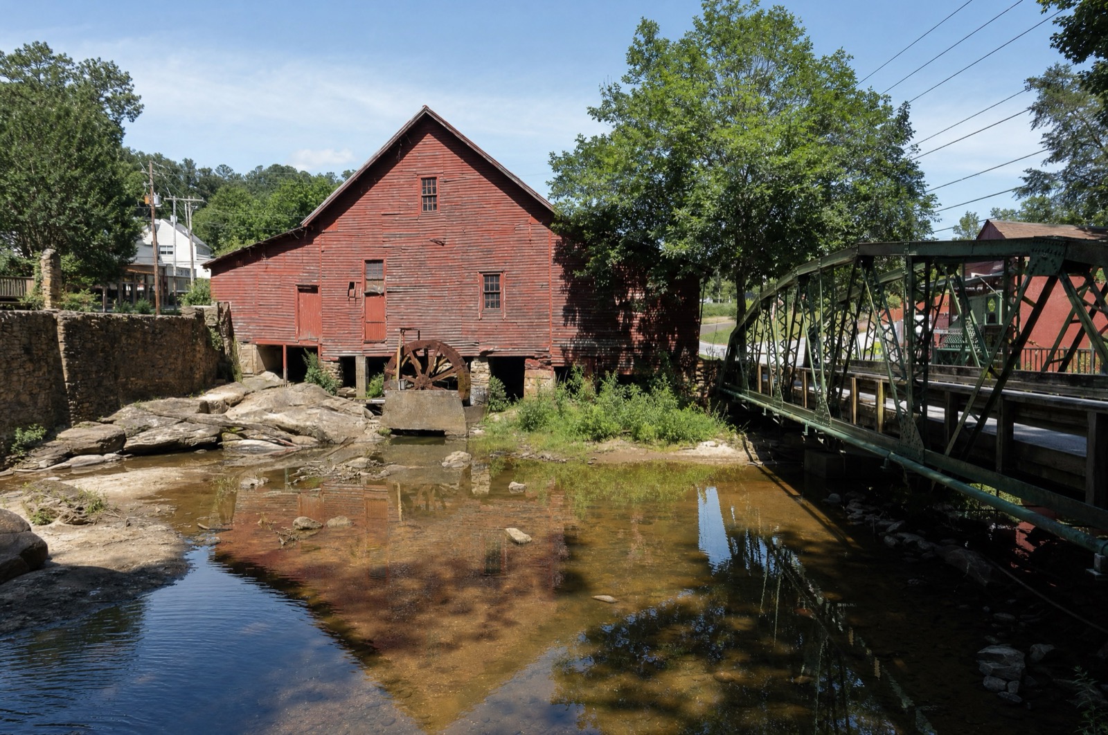 Historic red mill and steel truss bridge over the creek, Rex, GA