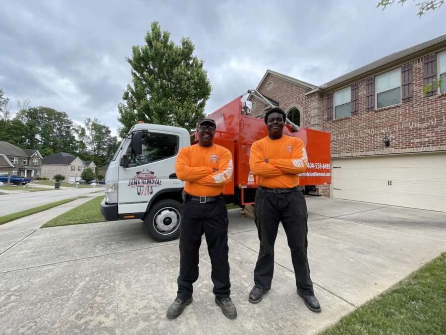Junk removal professionals smiling in front of their truck