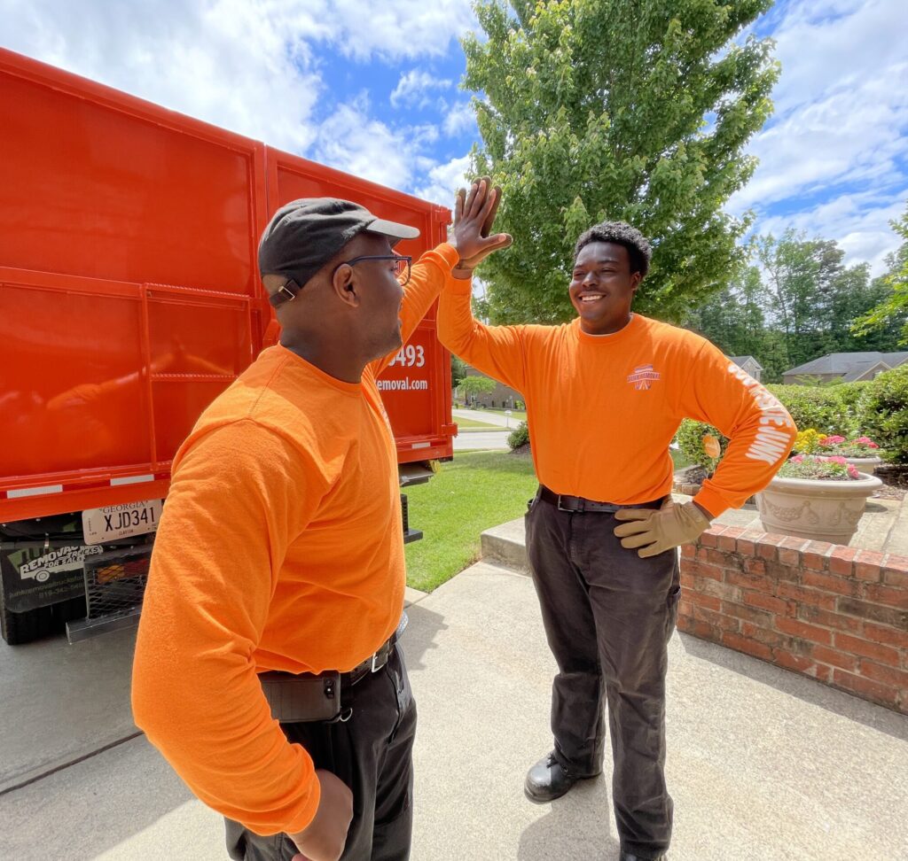 Southside Junk Removal high-fiving after completing a trash pickup job